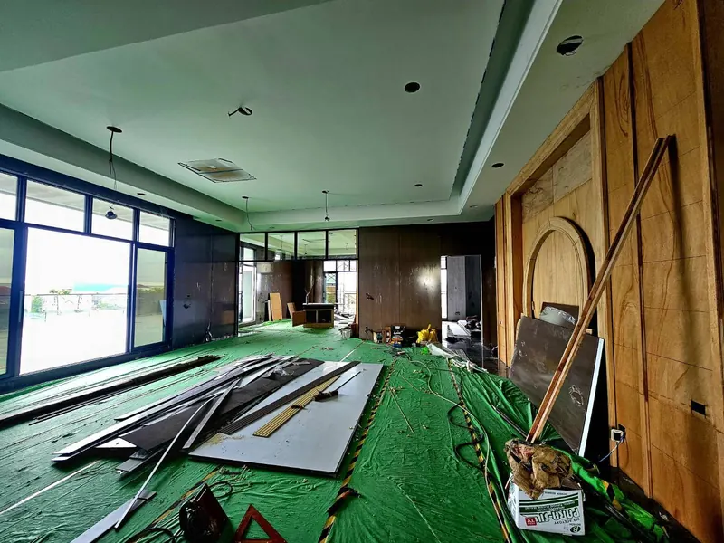 ห้องที่ตกแต่งภายในด้วยผนังไม้ ฝ้าหลุม ไฟดาวน์ไลต์ และแอร์ฝังฝ้า ระหว่างเก็บงาน